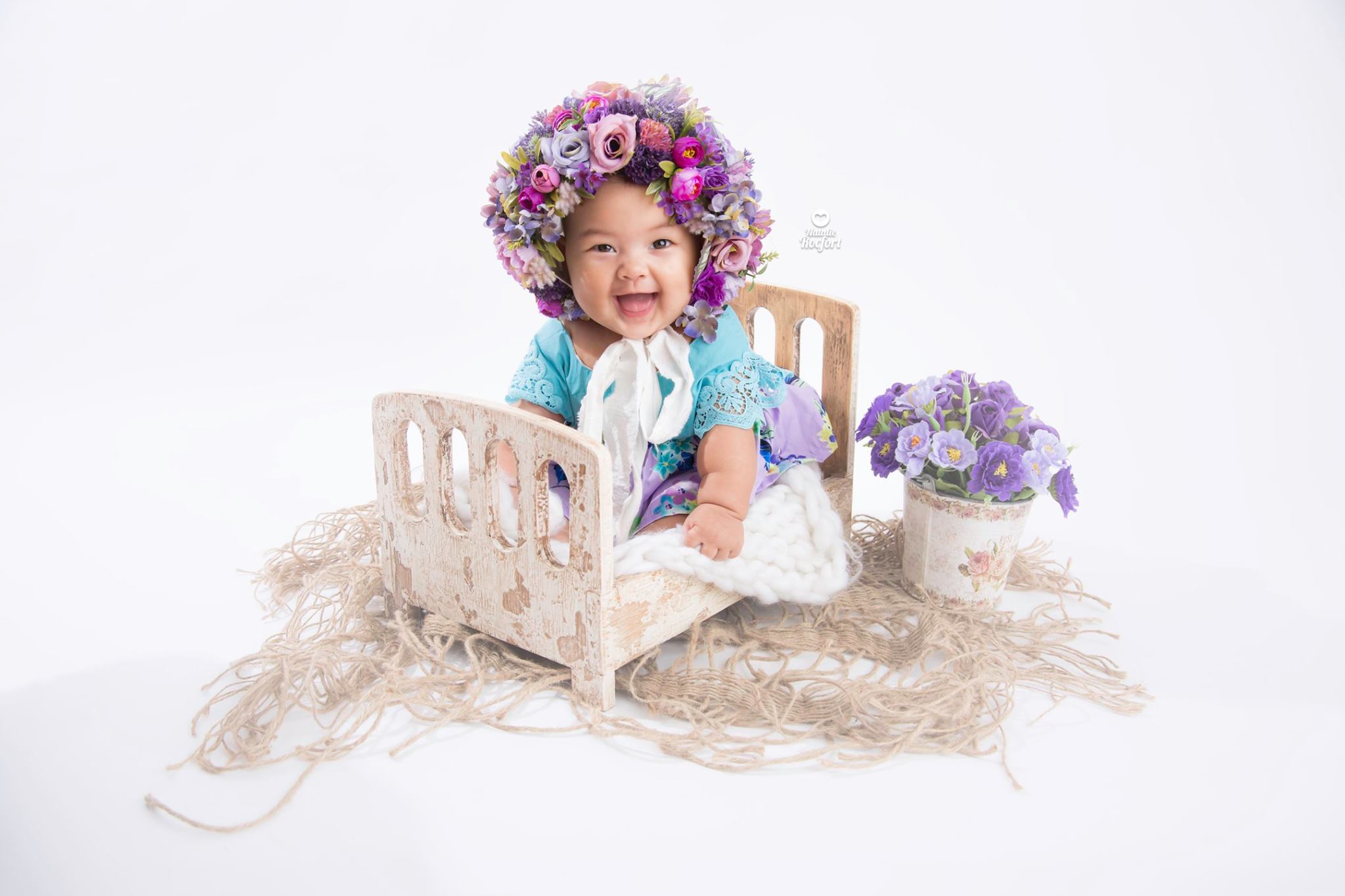 Vera Rocfort bebé en fondo blanco con gorro de flores, estudio de fotografía infantil Natalie Rocfort Lima Perú